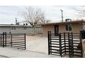 Tan house with a black metal gate and a small front yard at 5069 Hallet Dr, Las Vegas, NV 89122