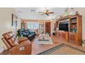Spacious living room with hardwood floors, leather furniture, and a large entertainment center at 7390 W Rome Blvd, Las Vegas, NV 89131