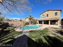 Spacious backyard with a sparkling pool and a covered patio, surrounded by lush greenery and privacy fencing at 7633 Winterthur Ct, Las Vegas, NV 89129