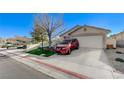 House exterior showcasing a red SUV parked in the driveway and a neatly landscaped yard at 8925 Medicine Wheel Ave, Las Vegas, NV 89143