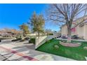 Landscaped front yard with a tree, sitting area, and American flag at 8925 Medicine Wheel Ave, Las Vegas, NV 89143