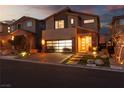 Charming two-story home featuring a modern glass garage door and inviting brick-paved driveway at 10936 White Alder Pl, Las Vegas, NV 89138