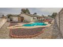 Inviting kidney-shaped pool in backyard with surrounding gravel at 1688 Crest Ave, Las Vegas, NV 89119