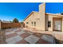 Backyard featuring a tan home and a red-and-grey tiled patio at 2177 Bridle Wreath Ln, Las Vegas, NV 89156