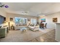 Spacious living room with light colored sofas and a large TV at 2612 Harrisburg Ave, Henderson, NV 89052