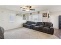 Spacious living room with neutral walls, dark leather couches and large windows at 2669 Champagne Gold Ave, North Las Vegas, NV 89086