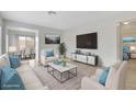 Virtually staged living room featuring light beige sofas and a large TV at 4642 Via San Rafael, Las Vegas, NV 89103