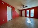 Living room with red walls, tile floors, and a view of the staircase at 569 Sellers Pl # 569, Henderson, NV 89011