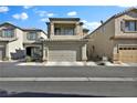 Two-story house with a tan exterior, attached garage, and balcony at 7868 Running Doe Ct, Las Vegas, NV 89149