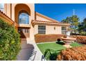 Landscaped front yard with a fountain, lush bushes, and a walkway to the front door at 8600 Kiel Ridge Cir, Las Vegas, NV 89117