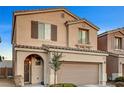 Two-story house with tan exterior, arched entryway, and landscaping at 10636 Tulip Valley Rd, Las Vegas, NV 89179