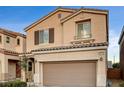 Two-story house with tan exterior, brown garage door, and landscaping at 10636 Tulip Valley Rd, Las Vegas, NV 89179