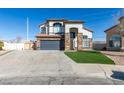 Charming two-story home with a stone facade, grey garage door and well manicured yard at 1138 Gainesborough Ct, Henderson, NV 89015