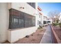 Condo exterior featuring security bars, drought tolerant landscaping, and a sidewalk at 1701 E Katie Ave # 65, Las Vegas, NV 89119