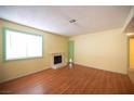 Bright living room featuring wood floors, large window, fireplace, and freshly painted walls at 1701 E Katie Ave # 65, Las Vegas, NV 89119