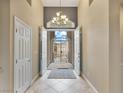 Open foyer with tile flooring, chandelier lighting and direct view of the front gate and door at 2026 Dakota Lodge Ave, Las Vegas, NV 89123