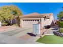 Single-story house with a two-car garage and American flag at 2084 Tiger Links Dr, Henderson, NV 89012