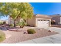 Single-story house with a two-car garage and desert landscaping at 2084 Tiger Links Dr, Henderson, NV 89012