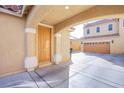 Covered driveway and front door of a tan two-story home with an attached garage at 2821 White Peaks Ave, North Las Vegas, NV 89081