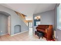 Open living room with tiled floors, staircase, and piano at 3241 Rainmaker St, Las Vegas, NV 89129