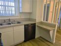 Kitchen featuring stainless steel dishwasher, white cabinets, and tile counter with a breakfast bar pass-through at 3823 S Maryland Pkwy # C3, Las Vegas, NV 89119