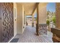 Covered patio entryway with stone columns and tile flooring at 4165 Kerberos Ave, North Las Vegas, NV 89084