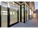 Modern home entryway with large glass windows and doors, stone pathway, and visible staircase at 506 Overlook Rim Dr, Henderson, NV 89012