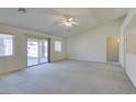 Large, open living space with neutral carpet, a ceiling fan, and easy access to the backyard at 5582 Little Lake Ave, Las Vegas, NV 89122