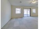 Spacious living room features carpet, a ceiling fan, large windows, and a sliding glass door at 5582 Little Lake Ave, Las Vegas, NV 89122