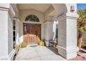 Elegant entryway with arched entry and a wood door at 6185 N Conquistador St, Las Vegas, NV 89149