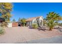 A single story home with a desert landscape, mature trees, and a gated gravel drive at 6185 N Conquistador St, Las Vegas, NV 89149