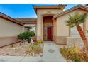 Inviting entryway with a decorative door and mature plants at 7079 Mountridge Dr, Las Vegas, NV 89110