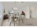 Virtually staged dining room featuring a round table and modern chandelier at 7568 Lily Trotter St, North Las Vegas, NV 89084