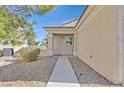 Front entry with walkway, decorative door, and drought-tolerant landscaping at 7568 Lily Trotter St, North Las Vegas, NV 89084