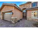 Front entrance with stone detailing and a double door at 7923 Sleeping Lily Dr, Las Vegas, NV 89178