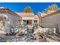 Front view of a home with a gated entry and Spanish tile roof at 9320 Quail Ridge Dr, Las Vegas, NV 89134