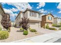 Two-story home featuring beige stucco, brown shutters, desert landscaping and a two car garage at 9332 Newbattle St, Las Vegas, NV 89178