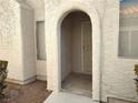 Inviting entryway with arched doorway and neutral exterior at 2119 Pebble Creek Ln, Laughlin, NV 89029