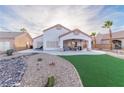 Artificial turf, rock landscaping and covered patio with lounge chairs at 1215 Country Club Dr, Laughlin, NV 89029
