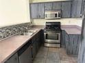 Kitchen features dark wood cabinets, stainless steel appliances, and tile backsplash at 16 Belle Essence Ave, Las Vegas, NV 89123