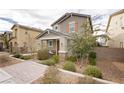 Two-story house with gray siding, brown door, landscaping, and a brick walkway at 2499 Adige Pl, Henderson, NV 89044