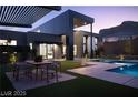 Modern backyard features a dining area, pool, spa, manicured lawn, and sleek architectural design at 4377 Cameron Brook Ct, Las Vegas, NV 89129