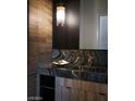 Modern bathroom features a marble countertop, wood cabinets, and designer lighting fixture at 4377 Cameron Brook Ct, Las Vegas, NV 89129