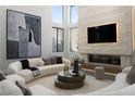 Bright, open living room featuring large windows, a stone fireplace, and modern curved sofas at 4377 Cameron Brook Ct, Las Vegas, NV 89129