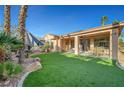 Artificial turf lawn, covered patio, and dining furniture at 4379 Bella Cascada St, Las Vegas, NV 89135