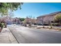 Gated community entrance with landscaping and paved road at 5023 Tunnel Falls Dr, Las Vegas, NV 89141