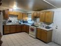 Functional kitchen features wooden cabinets, white countertops, and tiled floor at 1901 Belmont St, North Las Vegas, NV 89030