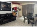 Another living area features a dark leather sofa, dining area and large framed art at 1901 Belmont St, North Las Vegas, NV 89030