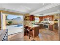 An indoor kitchen with a breakfast bar opens to a view of an outdoor swimming pool at 2410 Doherty Way, Henderson, NV 89014