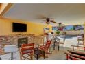 An outdoor covered patio includes a fireplace, barbecue, fan, and view of the swimming pool at 2410 Doherty Way, Henderson, NV 89014